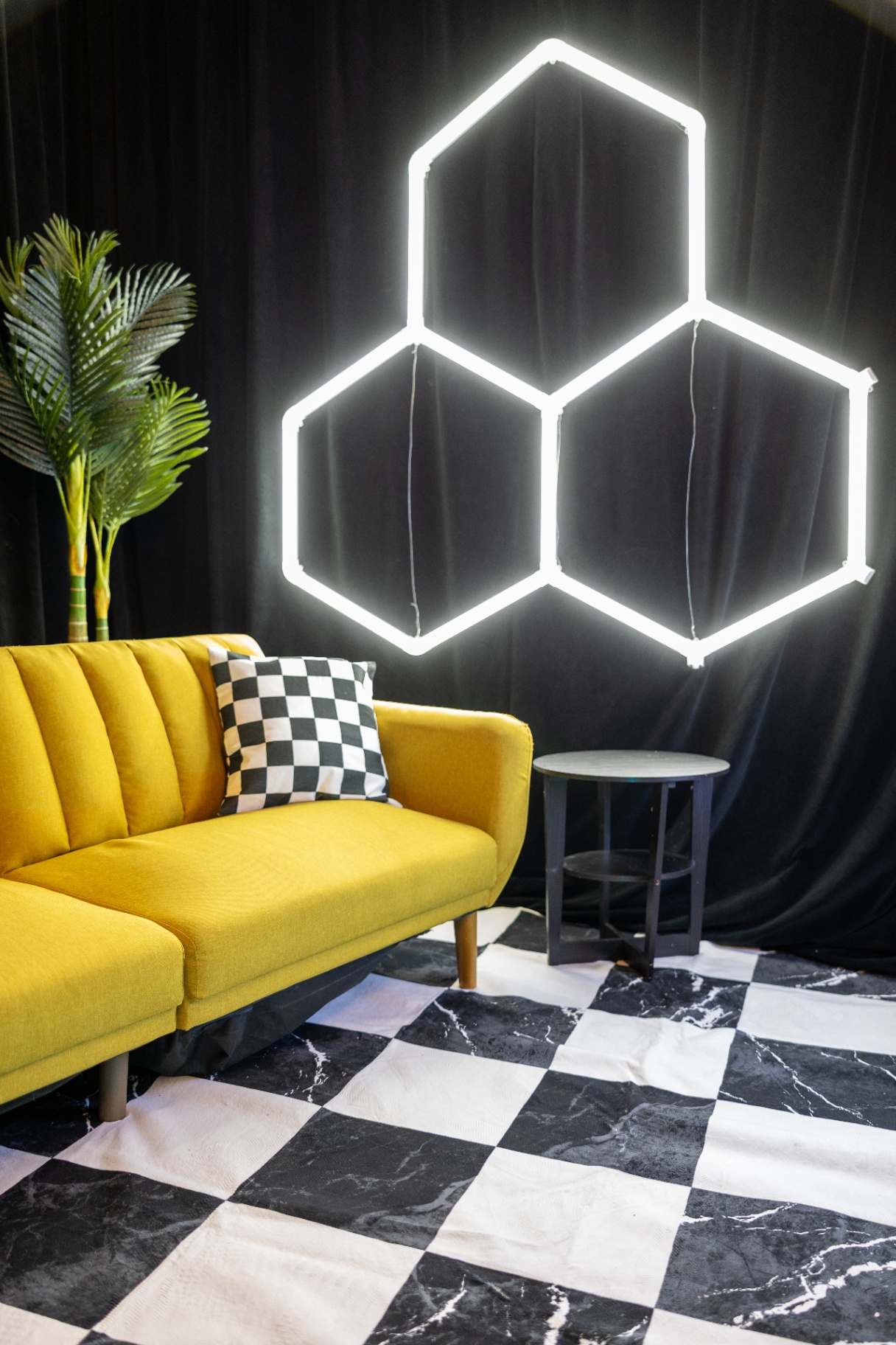 Hexagon neon backdrop with yellow couch
